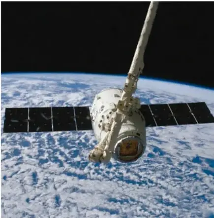 Fotografía de una sonda espacial con paneles solares desplegados en órbita, con la Tierra de fondo.