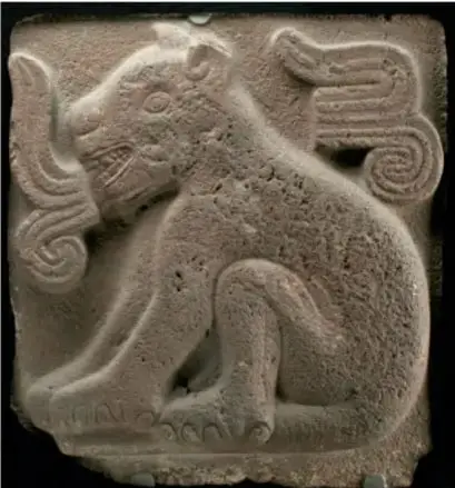 Relieve en piedra de un jaguar estilizado, con grecas y cola rizada, procedente del arte mexica.