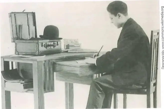 Fotografía histórica de un trabajador del sector terciario realizando labores de oficina.