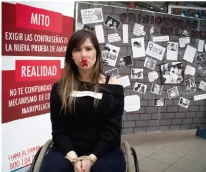 Mujer joven sentada frente a un muro con carteles que contrastan 'mito' y 'realidad' sobre la manipulación y las contraseñas.
