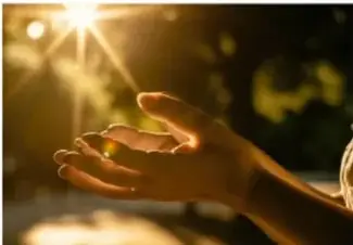 Mano recibiendo el calor de los rayos del Sol, ilustrando la radiación.