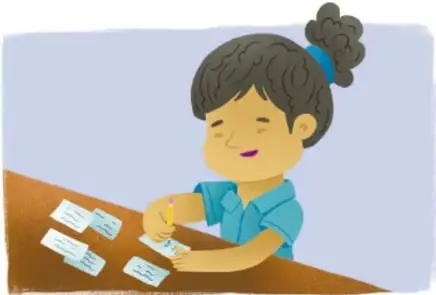 Niña con coleta sonríe mientras escribe en pequeños papeles o notitas sobre una mesa. Crédito: Carlos Emmanuel Cano Morales.