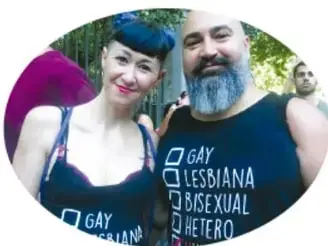 Fotografía de dos personas con playeras que llevan impresas las palabras GAY, LESBIANA, BISEXUAL y HETERO.