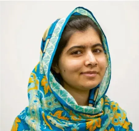 Fotografía de Malala Yousafzai con hijab azul estampado, de frente, mirando a la cámara.