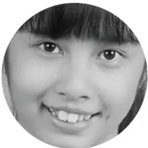 Fotografía circular en blanco y negro del rostro sonriente de un estudiante.