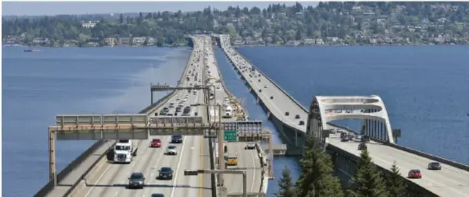 Puente flotante sobre un lago con tráfico de autos y camiones.