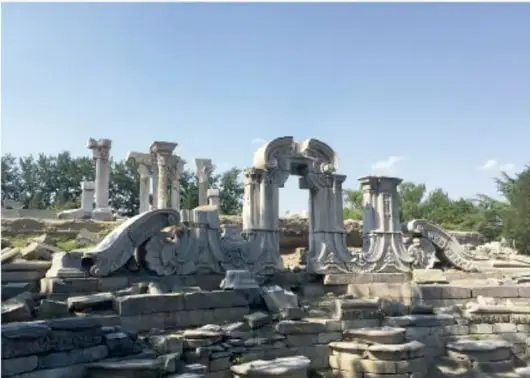 Fotografía de las ruinas del Antiguo Palacio de Verano de Pekín, con columnas de piedra y restos arquitectónicos.