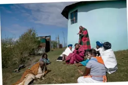 Grupo de personas sentadas en círculo al aire libre, dialogando o compartiendo saberes.