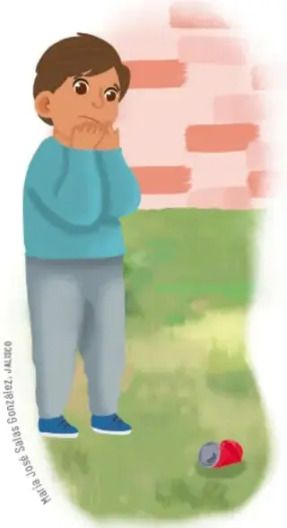 Niño pensativo junto a un muro, con residuos en el suelo.