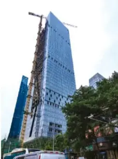 Edificio alto en construcción con grúa, rodeado de árboles, ejemplo de obra humana que altera el ambiente.
