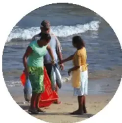 Fotografía de personas (adultos y niños) en la playa frente al mar, junto al texto 'Grupos afrodescendientes'.