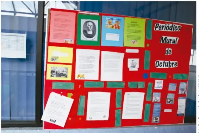 Fotografía de un periódico mural escolar de fondo rojo titulado "Periódico Mural de Octubre" con recortes, fotografías y textos; crédito: Salatiel Barragán Santos, SEP.