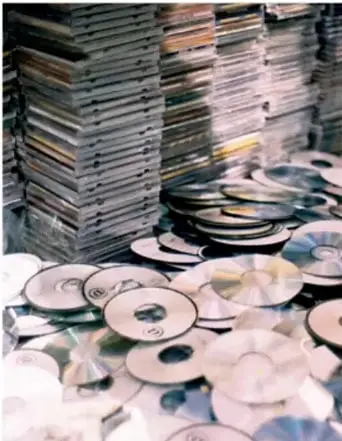 Pila de discos compactos (CD) apilados y dispersos sobre una superficie, relacionados con obras y derechos de autor.