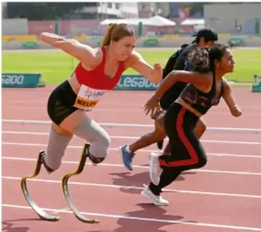 Atletas con prótesis de carrera compitiendo en pista de atletismo.