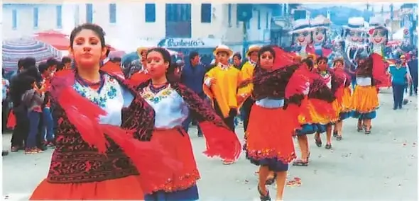 Fotografía de una celebración cultural con personas vestidas con trajes tradicionales y pañuelos, relacionada con Cuenca.