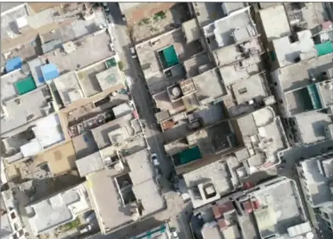 Vista aérea de una comunidad con casas, calles y techos, útil como ejemplo de croquis.