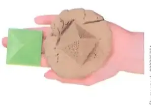 Mano que sostiene una pieza de arcilla o plastilina junto a un molde o desarrollo geométrico.