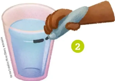 Mano vertiendo agua en un vaso de plástico transparente y marcando el nivel con un plumón.