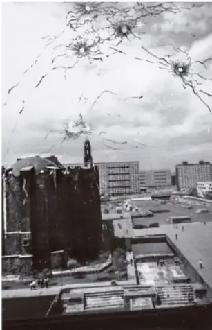 Fotografía histórica en blanco y negro de la Plaza de las Tres Culturas en Tlatelolco, Ciudad de México, con el edificio Chihuahua y la unidad habitacional, tomada a través de un cristal agrietado, evocando la represión del 2 de octubre de 1968.