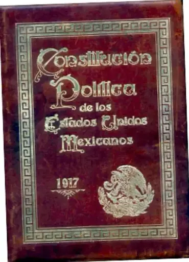 Fotografía de la tapa del libro 'Constitución Política de los Estados Unidos Mexicanos 1917', en piel roja con detalles dorados y el escudo nacional.