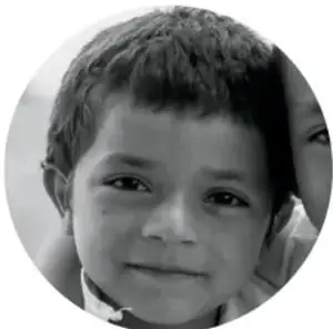Retrato circular en blanco y negro de una niña sonriendo, acompañada por otra persona al fondo.