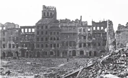 Fotografía en blanco y negro de una ciudad europea en ruinas tras la Primera Guerra Mundial, con edificios destruidos y escombros.