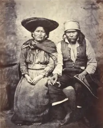 Fotografía histórica en blanco y negro de una pareja de indígenas de Quito, tomada en 1868 por Courret Hermanos.