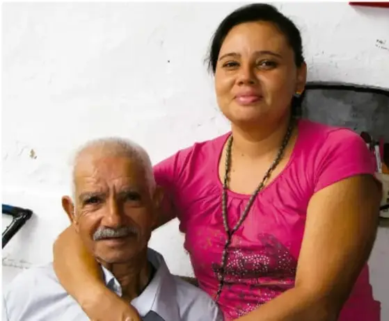 Fotografía de una mujer joven con un hombre mayor, probablemente entrevistando a un anciano de la comunidad.