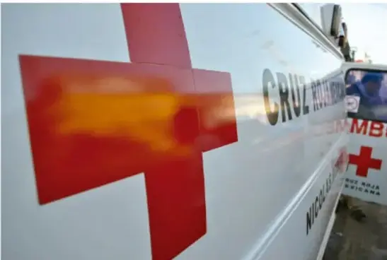 Fotografía de una ambulancia de la Cruz Roja con su característica cruz roja sobre carrocería blanca.