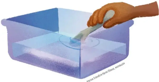 Manos vertiendo sal en un recipiente amplio de plástico con agua.