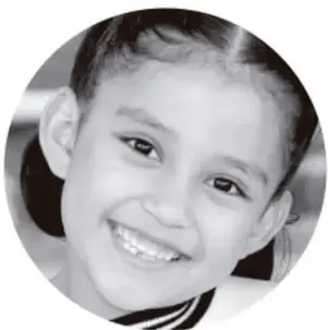 Fotografía en blanco y negro de una niña sonriente en un recorte circular.