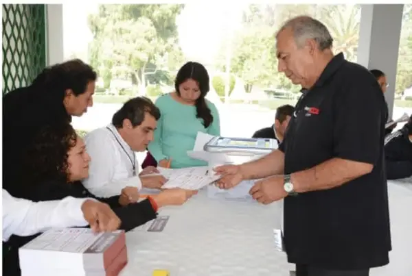 Ciudadanos y autoridades reunidos alrededor de una mesa revisan documentos durante una actividad de participación o consulta pública.