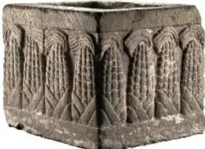Bloque de piedra tallada con figuras geométricas y antropomorfas, posiblemente un altar o elemento arquitectónico prehispánico.