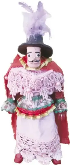 Fotografía de un muñeco huehue con sombrero de ala ancha, pluma clara, máscara de piel rosada con bigote, capa roja y vestido con encaje blanco.