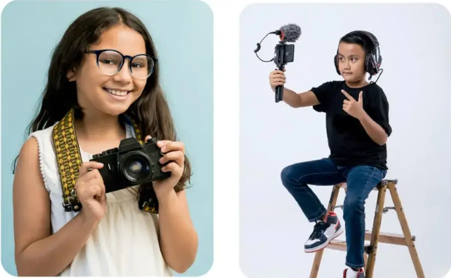 Niña con lentes sosteniendo una cámara fotográfica, sonriendo.