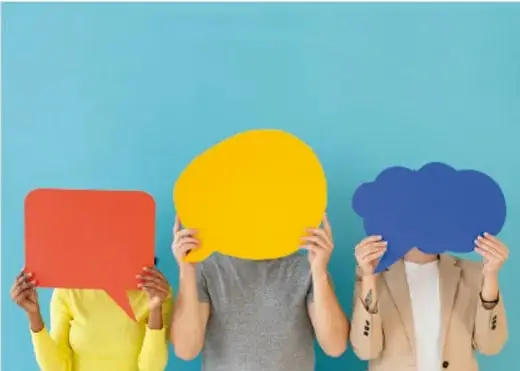 Fotografía de tres personas sosteniendo formas de colores (cuadrado rojo, óvalo amarillo, nube azul) que cubren sus rostros, ilustrando la comunicación no verbal y los formatos de la comunicación.