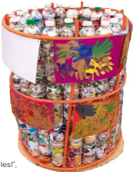 Fotografía de un bote grande elaborado con botellas de plástico reutilizadas, unidas con cintas naranjas y decorado con dibujos de manos de colores y figuras de aves. Tiene un letrero blanco en la parte superior.