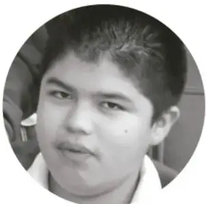 Fotografía en blanco y negro de un estudiante de primaria con uniforme escolar.