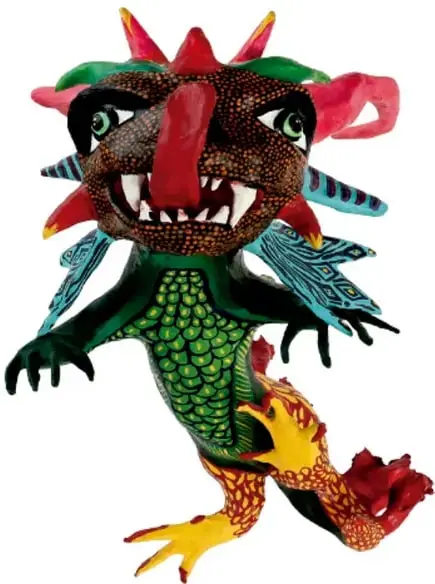Alebrije con cabeza oscura, grandes ojos, boca con dientes blancos, cuernos rojos, alas azules, torso verde con escamas y patas amarillas y rojas.