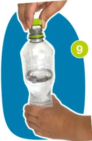 Mano sosteniendo una regla junto a la botella para medir el nivel del agua.