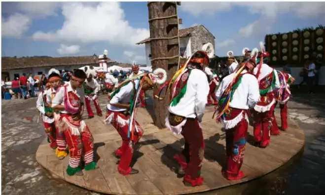 Fotografía de un grupo de danza tradicional sobre una tarima circular en una plaza comunitaria (crédito: Carlos Hahn, EL UNIVERSAL).