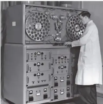 Fotografía en blanco y negro de un técnico operando una gran computadora antigua.