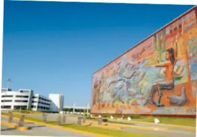 Mural urbano de gran extensión en una avenida, atribuido a Salatiel Barragán Santos, Veracruz, con figuras humanas y colores cálidos.
