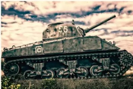 Fotografía de un tanque de guerra avanzando en un campo.