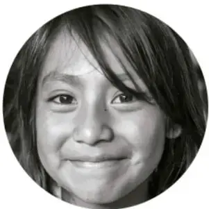 Fotografía en blanco y negro de una niña sonriente, símbolo de la niñez protegida.