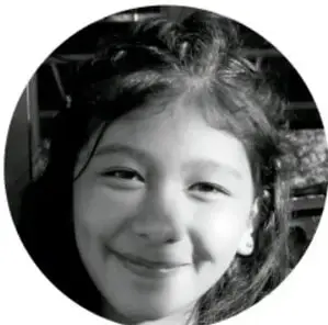 Fotografía en blanco y negro de una niña sonriente, como imagen de apertura del escenario comunitario.