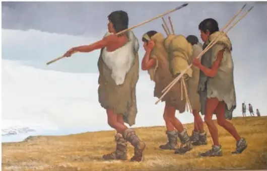 Ilustración de un grupo de personas prehistóricas caminando por un paisaje nevado, portando lanzas y pieles.