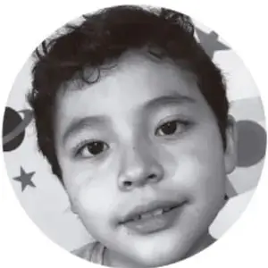 Fotografía en blanco y negro de un niño de primaria con cabello corto y oscuro, mirando de frente, dentro de un círculo con estrellas decorativas.