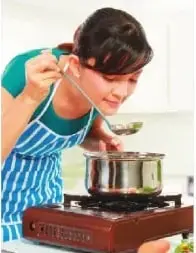 Niña probando una preparación; la imagen destaca la relación entre los sentidos del gusto y del olfato.
