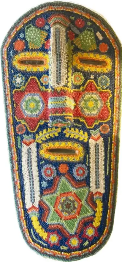 Chinelo de Morelos: máscara con bigote y barba, montera alta de terciopelo con bordado de mariposa, flecos de ixtle y cuentas rosa y doradas; traje amarillo con plumas.